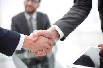 Men shaking hands with smile at office with their coworkers.