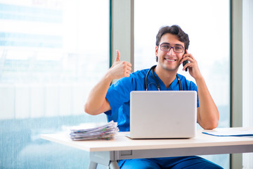 Young handsome doctor working in the hospital 