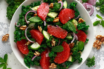Healthy vegan food, vegetarian Grapefruit kale salad with walnuts, red onion and cucumber - obrazy, fototapety, plakaty