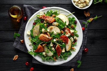 Pear, chicken salad with blue cheese, cranberry and walnuts. concept healthy food. black background