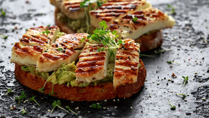 Avocado and grilled haloumi cheese toast with nigella and sesame seeds. healthy breakfast