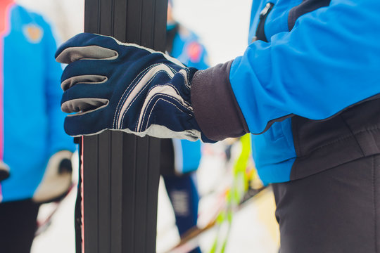 woman hand in gloves hold ski close up.