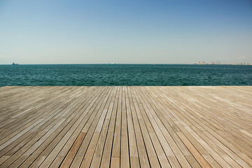 wooden deck waterfront sea shoreline background texture and water surface with small waves with...