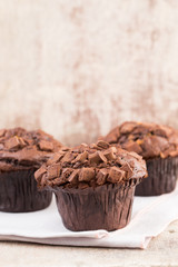 Homemade muffins with chocolate, vintage background.