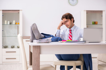 Young attractive businessman working in the office  