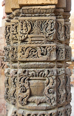 Column with intricate stone carving in courtyard of  Qutub complex, Delhi, India