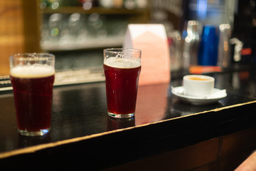 Beer glasses with dark beer are on the bar counter