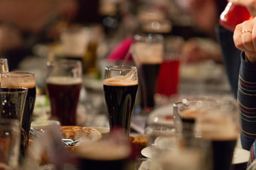 Beer glasses with dark beer are on the bar counter