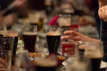 Beer glasses with dark beer are on the bar counter