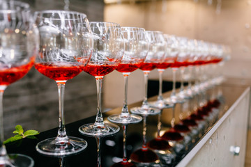 Red cocktail with strawberries. Strawberry daiquiri made with rum,brandy,lime juice, fresh strawberries,grenadine. Refreshing cocktails for a big company. A party. Soft focus.