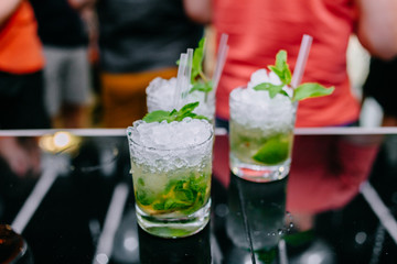 The cocktail is green. Light rum, peppermint leaves, fresh lime juice and ice. Refreshing cocktails for a big company. A party