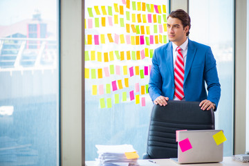 Young handsome employee with many conflicting priorities   