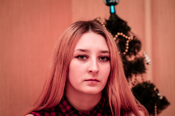 Portrait of a beautiful girl on the background of the Christmas tree