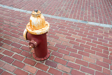 red white rusted fire hydrant on brick walkway sidewalk
