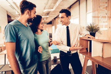 Young Couple Consulting With Furniture Seller.
