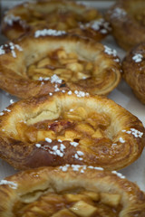 one serving size baked golden brown apple pies in a row at the market