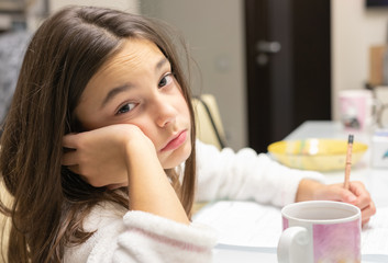beautiful girl in a white t-shirt doing homework