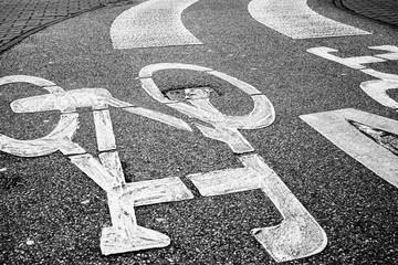 pedestrian crossing accross curved bicycle asphalt line, high contrast photo