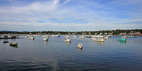 Lobster boats of Bass Harbor, Maine, at anchor in the harbor on a quiet summer afternoon.