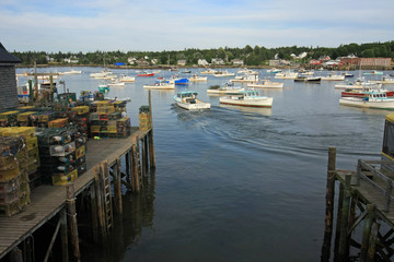 Fototapeta na wymiar Lobster boats of Bass Harbor, Maine, at anchor in the harbor on a quiet summer afternoon.