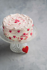 Birthday cake for Valentine's Day with pink hearts and colorful sprinkles. Valentine's day card background with copy space.