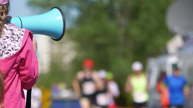Girl cheering runners by megaphone in 4k slow motion 60fps - Powered by Adobe