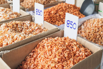 Traditional dried shrimp with price tag in the bucket for sale in the most famous market in Chinatown district, Bangkok, Thailand. Selective focus