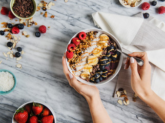 Acai bowl with blueberry, banana, coconut, granola and raspberries