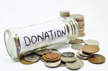 Donation lable in a glass jar with coins spilling out