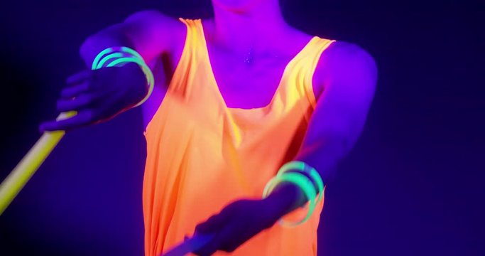 Slow motin of beautiful sexy women with fluorescent make-up and clothing dancing in neon light. Night club, Party Concept.