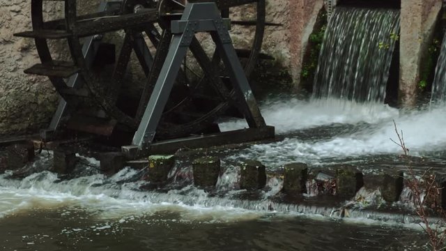 Ultra HD video of wooden watermill driven by falling river stream 