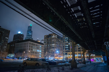 Fototapeta na wymiar Chicago skyline with a vintage urban city railway bridge and alley during the winter at night