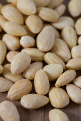 peeled almonds on wooden surface