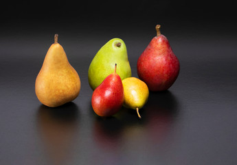 Healthy and nutritious snacks.  Delicious fresh pears on a black background.  Forelle, Bosc, D'Anjou, Starkrimson Red Pears variety.