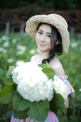 Fototapeta premium Beautiful girl with a field of hydrangea flowers.