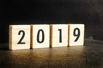 Welcome 2019 concepttual with 2019 printed on a wooden block over vintage background. © tuahlensa