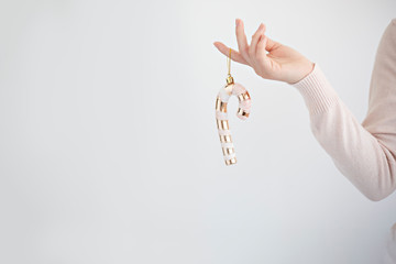 hand holding a gold candy cane on white background