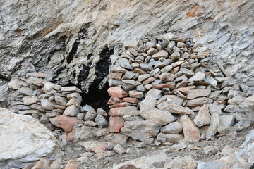 Tibet. Stoned entrance to small cave on the shore of Rakshas Tal lake