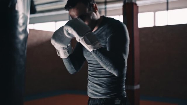 fit boxer training martial arts on a punching bax