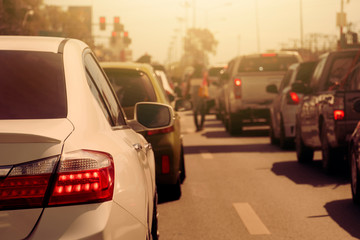 Hot tone color of cars on the road in traffic junction stop by red light control in Thailand.