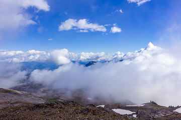 flufffy white cloused over a snowy mountain