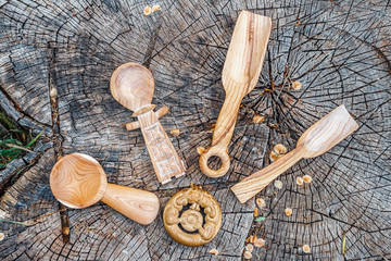 Collection of handmade wooden spoons on a stump
