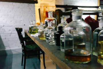 Close up amber color bottles on the shelf in old perfume laboratory. Flasks and examples of odor in the perfume shop.