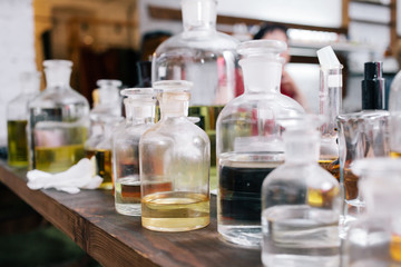 Close up amber color bottles on the shelf in old perfume laboratory. Flasks and examples of odor in...