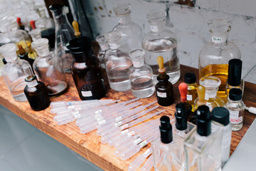 Close up amber color bottles on the shelf in old perfume laboratory. Flasks and examples of odor in the perfume shop.