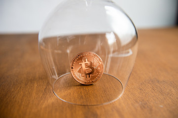 Bitcoin covered by a glass