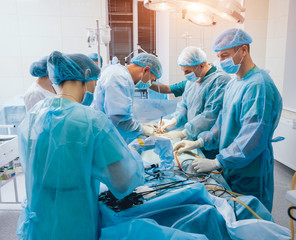 Process of gynecological surgery operation using laparoscopic equipment. Group of surgeons in operating room with surgery equipment
