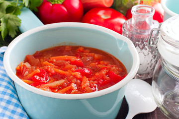 Letcho with tomatoes, peppers and carrots in an enamelled ladle, horizontal