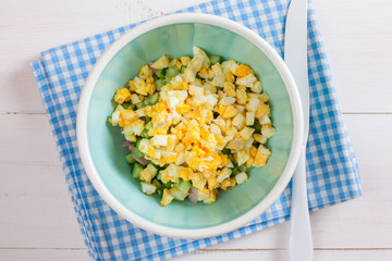 Step by step cooking salad with smoked chicken, corn, crackers, step 3 - adding ingredients - boiled chopped egg, top view, horizontal