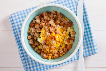 Step-by-step cooking salad with smoked chicken, corn, crackers, step 5 - adding ingredients - crackers, top view, horizontal